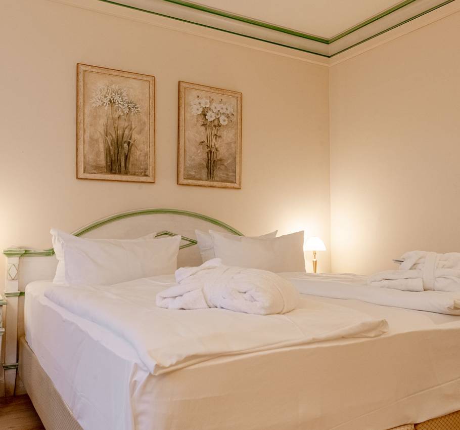 Doppelzimmer im Rugard Strandhotel Binz mit Blick auf das Bett und stilvolle Wanddekoration.