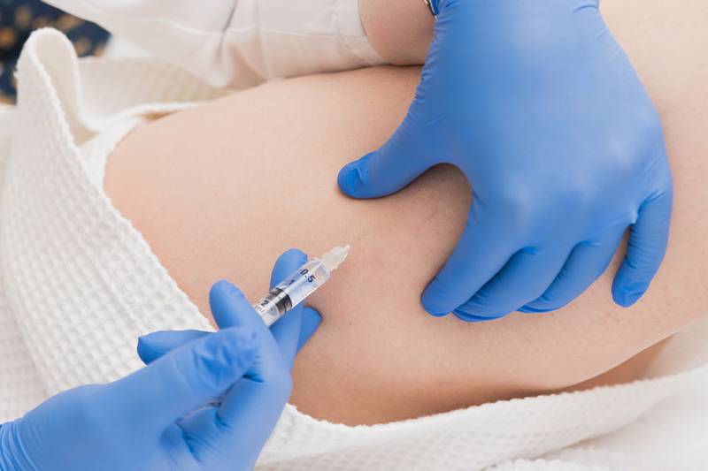 Detailed shot of a medical injection lipolysis with blue gloves from ÄsthetikaMed in the Arkona Strandhotel on Rügen.