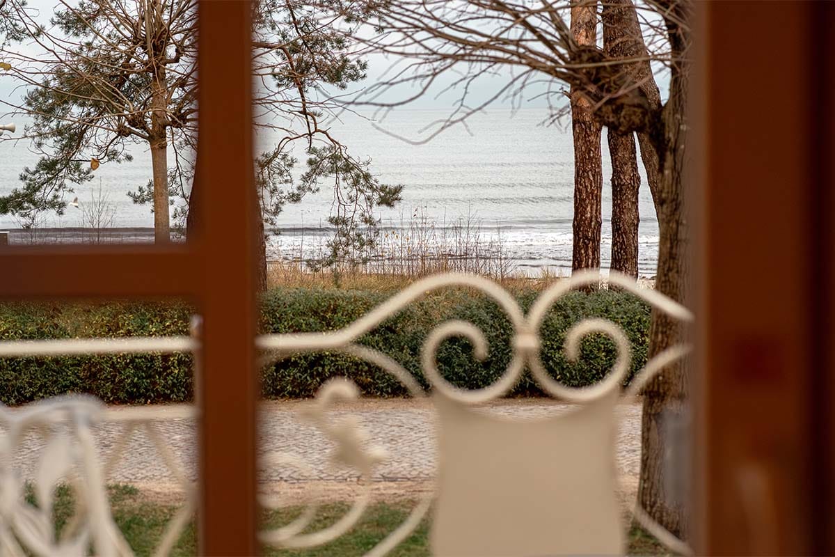 View of the sea through the white ornamental balcony railing at Rugard Thermal Strandhotel Binz