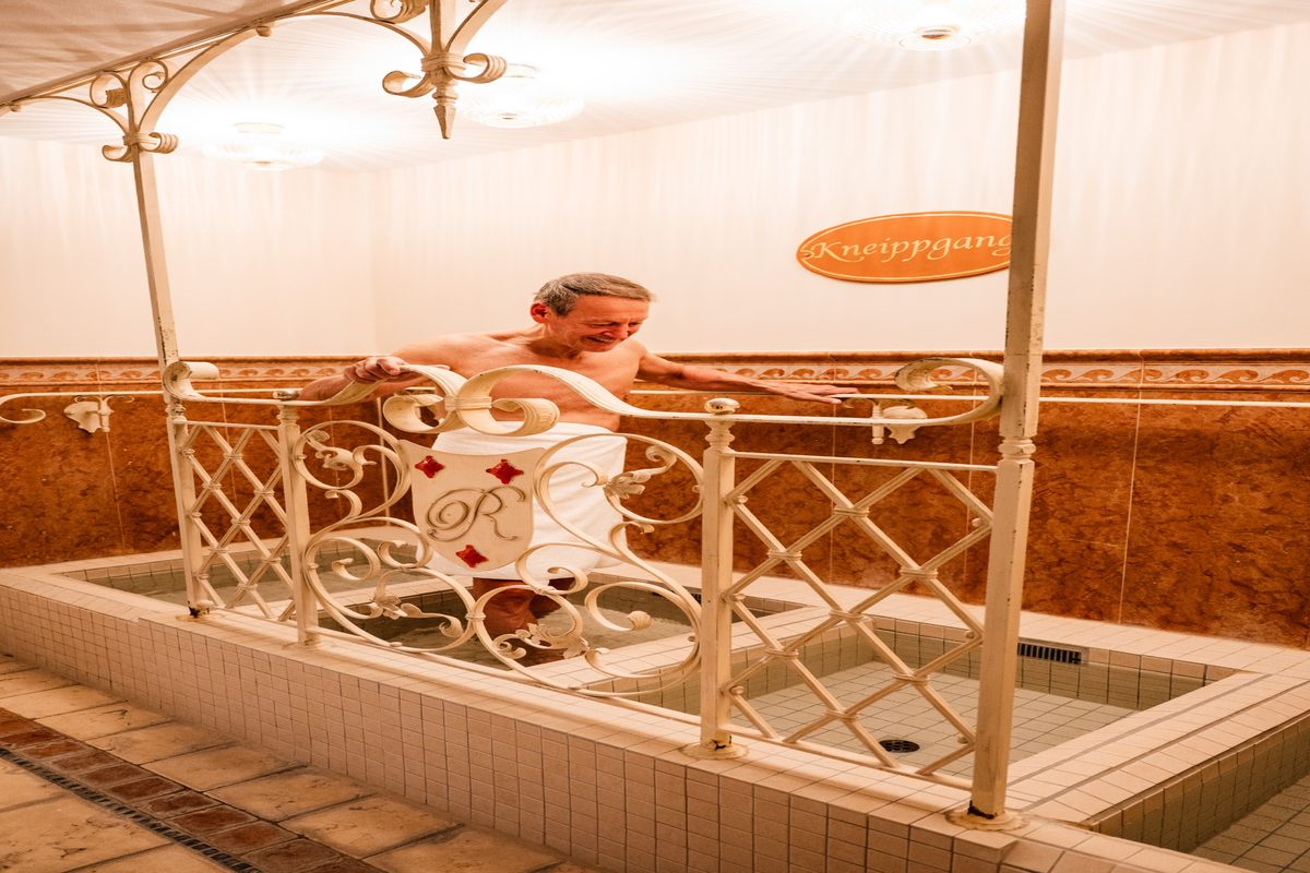 Gast nutzt den Kneippgang im Wellnessbereich des Rugard Strandhotels in Binz.
