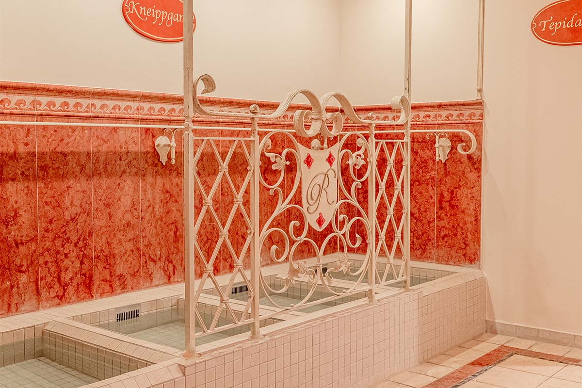 Close-up of a Kneipp path with sunken basin and decorative cast iron railing at the Rugard Thermal Strandhotel.