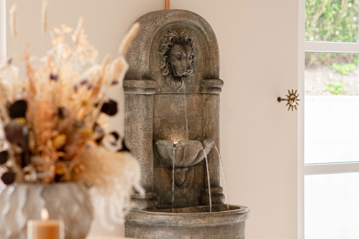 Water flows from the lion's head fountain over several levels in the wellness area of the Rugard Thermal Strandhotel.