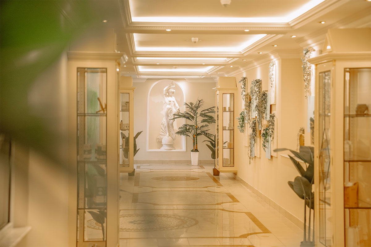 An elegant corridor in the spa, featuring plants and a sculpture, at the Rugard Thermal Strandhotel in Binz on Rügen