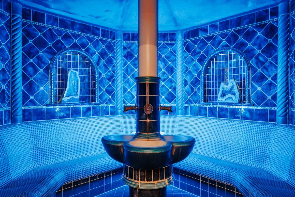 Interior of the blue gemstone grotto with round bench and steam spring at the Rugard Thermal Strandhotel.
