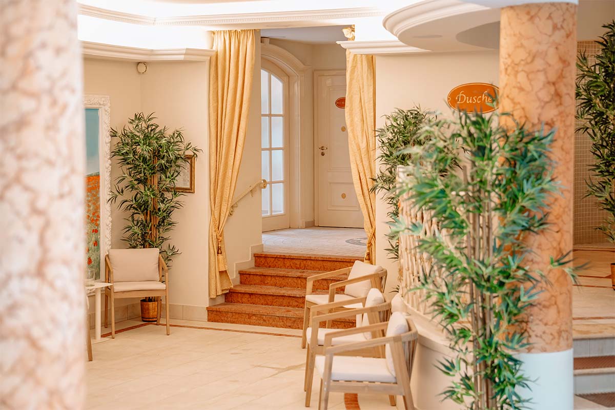 A view of the relaxation area with loungers, floral arrangements and warm lighting at the hotel with a sauna in Binz on Rügen.