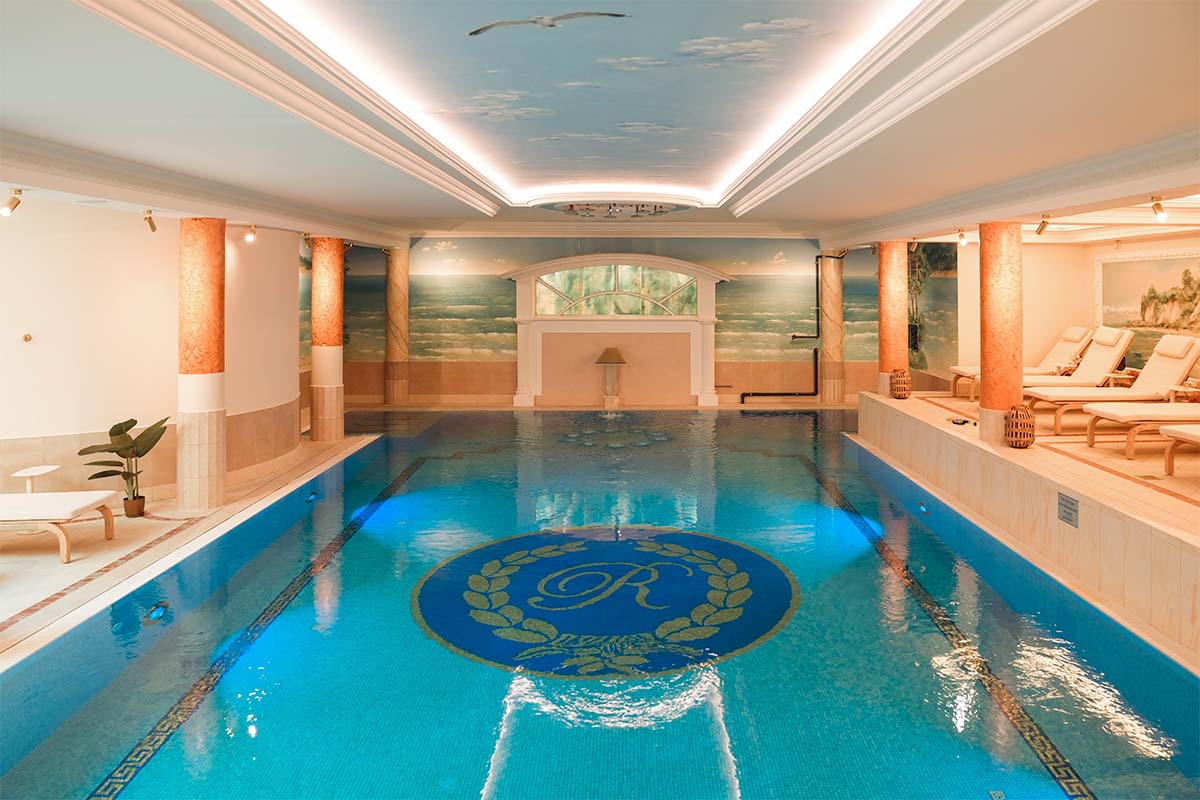 Spacious pool with Mediterranean mural and mosaic ornament in the wellness area of the Rugard Strandhotel