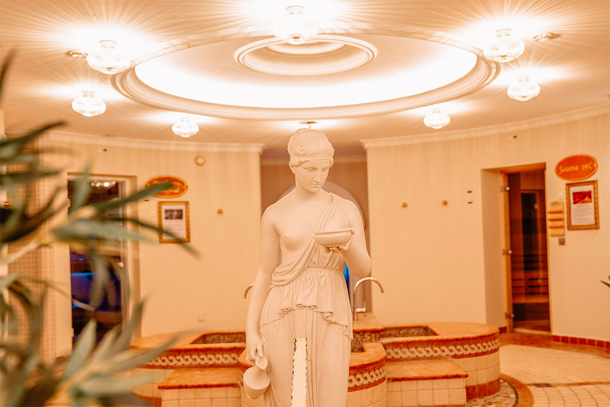 Interior view of the spa, featuring a statue and fountain in the wellness area of the Rugard Thermal Strandhotel on Rügen