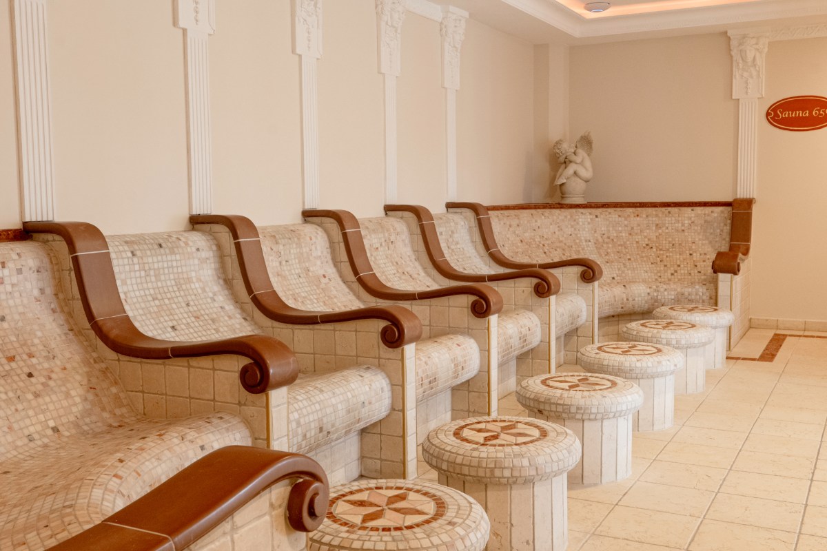 Elegant relaxation room in the tepidarium with heated stone loungers in the Mediterranean style of the Rugard Strandhotel.