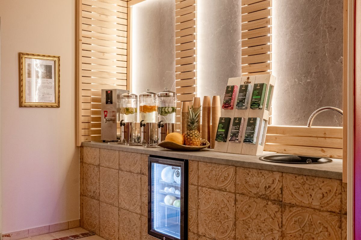 Water station with glass dispensers, fresh fruit and drinking cups in the spa area of the Rugard Thermal Hotel.